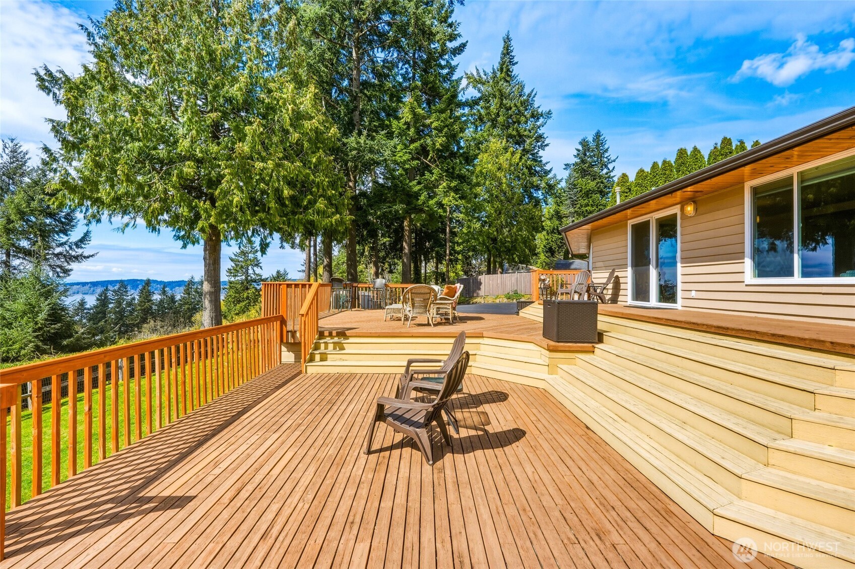 8910 56th Place West Mukilteo, WA 98275 - Photo 32 of 40 a view of a patio with dining table and chairs with wooden floor and fence