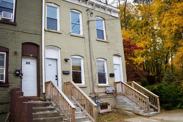 a view of a building with stairs and wooden fence