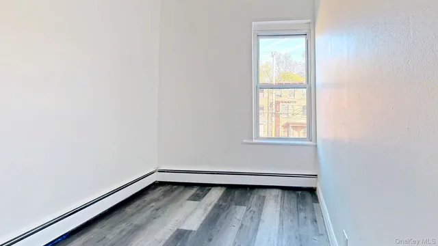 a view of a small space with wooden floor and a window