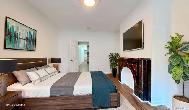 a bedroom with a bed a mirror on the wall and a flat screen tv