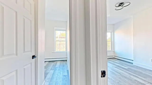 a view of a hallway with wooden floor and entryway