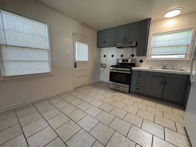 a kitchen with stainless steel appliances a sink stove and cabinets