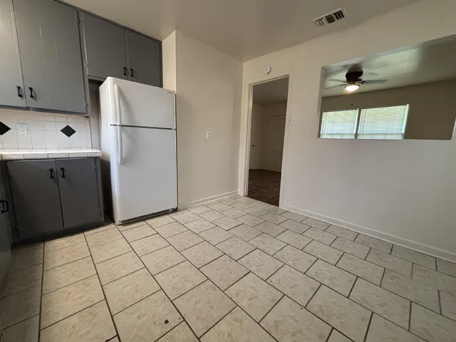 a kitchen with a refrigerator and cabinets