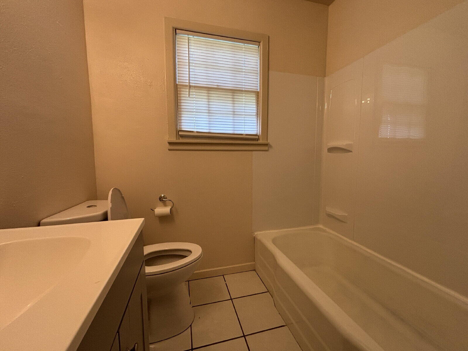 2707 East 9th Street Lubbock, TX 79403 - Photo 8 of 8 a bathroom with a granite countertop sink a toilet and a bathtub