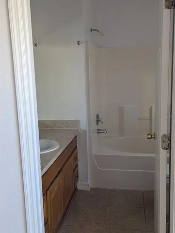 a bathroom with a tub sink and shower