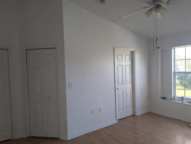an empty room with windows and closet