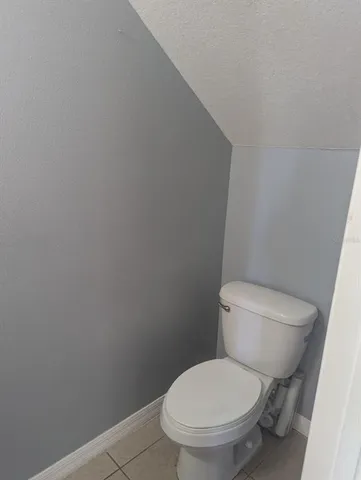a white toilet sitting next to a white wall