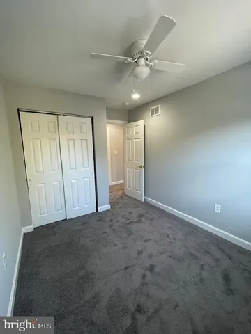 an empty room with fan and entrance