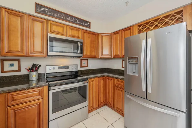 a kitchen with stainless steel appliances granite countertop a refrigerator sink and microwave