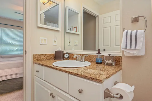 a bathroom with a granite countertop sink and a mirror