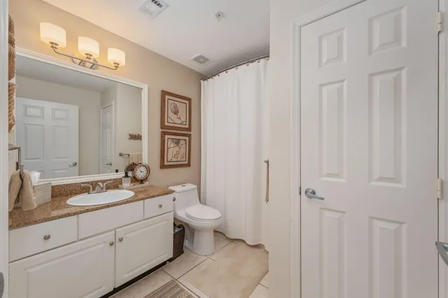 a spacious bathroom with a double vanity sink a mirror and a toilet