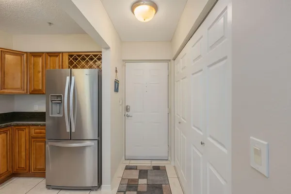 a view of kitchen with refrigerator and wooden floor