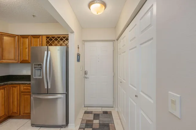 a view of kitchen with refrigerator and wooden floor