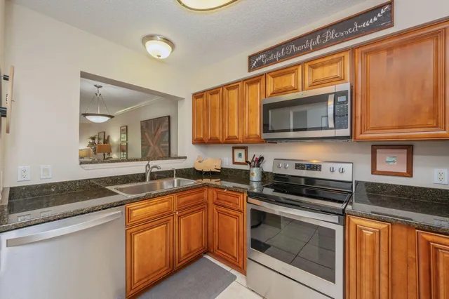 a kitchen with stainless steel appliances granite countertop a stove microwave and sink