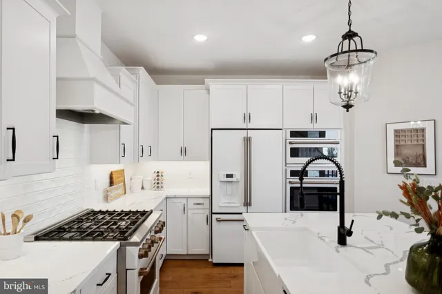 a kitchen with stainless steel appliances a stove a sink a refrigerator and cabinets