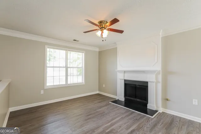 an empty room with windows and a fireplace