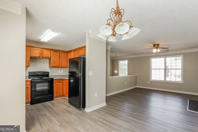 a kitchen with stainless steel appliances granite countertop a refrigerator a stove a sink dishwasher and wooden floor