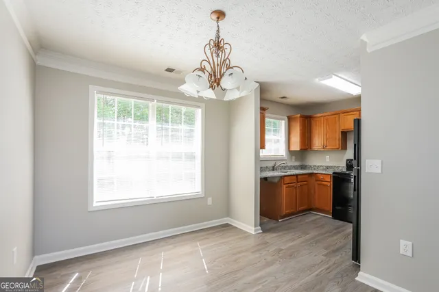 a kitchen with stainless steel appliances granite countertop hardwood floor sink stove and granite counter top