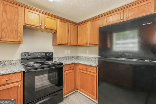 a kitchen with granite countertop cabinets stainless steel appliances and a counter space