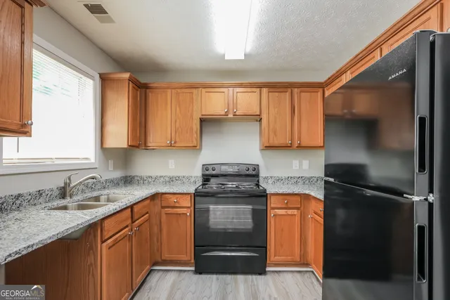a kitchen with a sink stove and refrigerator
