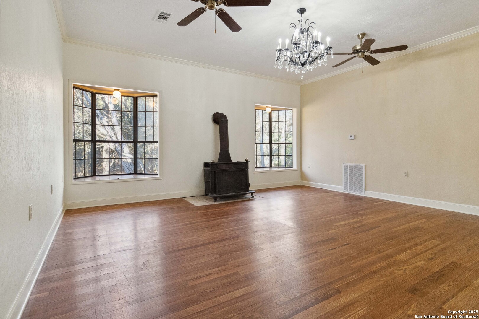 19517 Scenic Loop Road Helotes, TX 78023 - Photo 12 of 55 a view of a livingroom with wooden floor a ceiling fan and windows