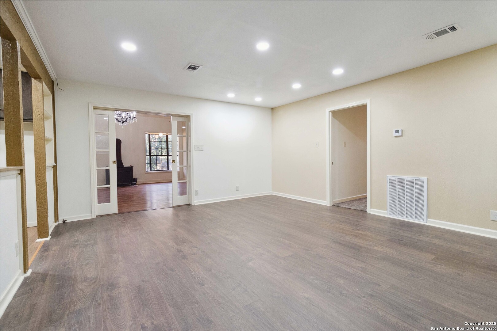 19517 Scenic Loop Road Helotes, TX 78023 - Photo 26 of 55 an empty room with wooden floor and windows
