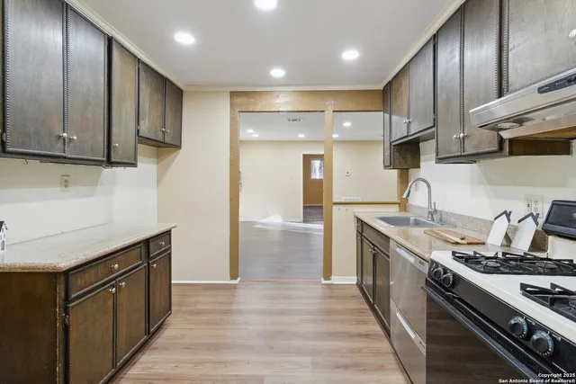 a kitchen with wooden cabinets and stainless steel appliances