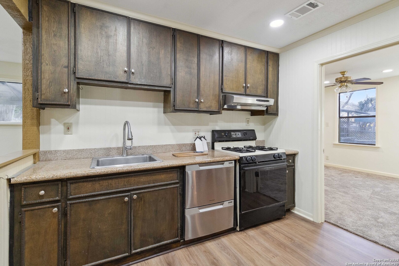 19517 Scenic Loop Road Helotes, TX 78023 - Photo 28 of 55 a kitchen with stainless steel appliances granite countertop wooden cabinets a sink and dishwasher