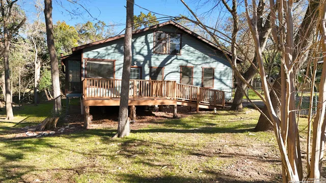 a view of a house with a big yard and large trees