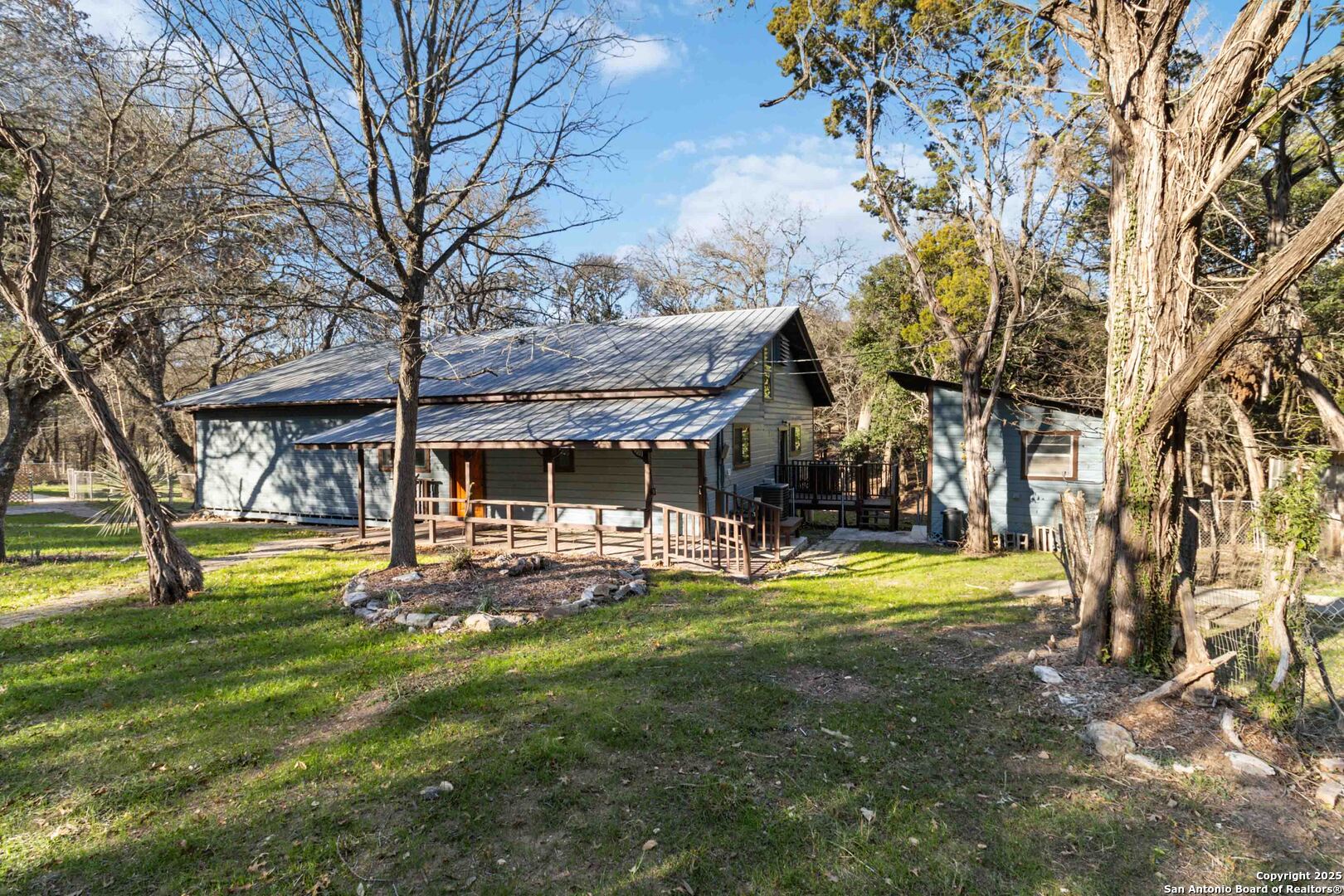 19517 Scenic Loop Road Helotes, TX 78023 - Photo 5 of 55 a view of a house with a big yard and large trees