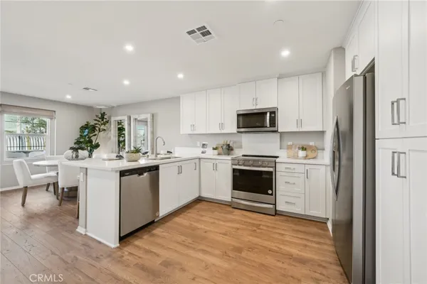 a kitchen with white cabinets and white appliances