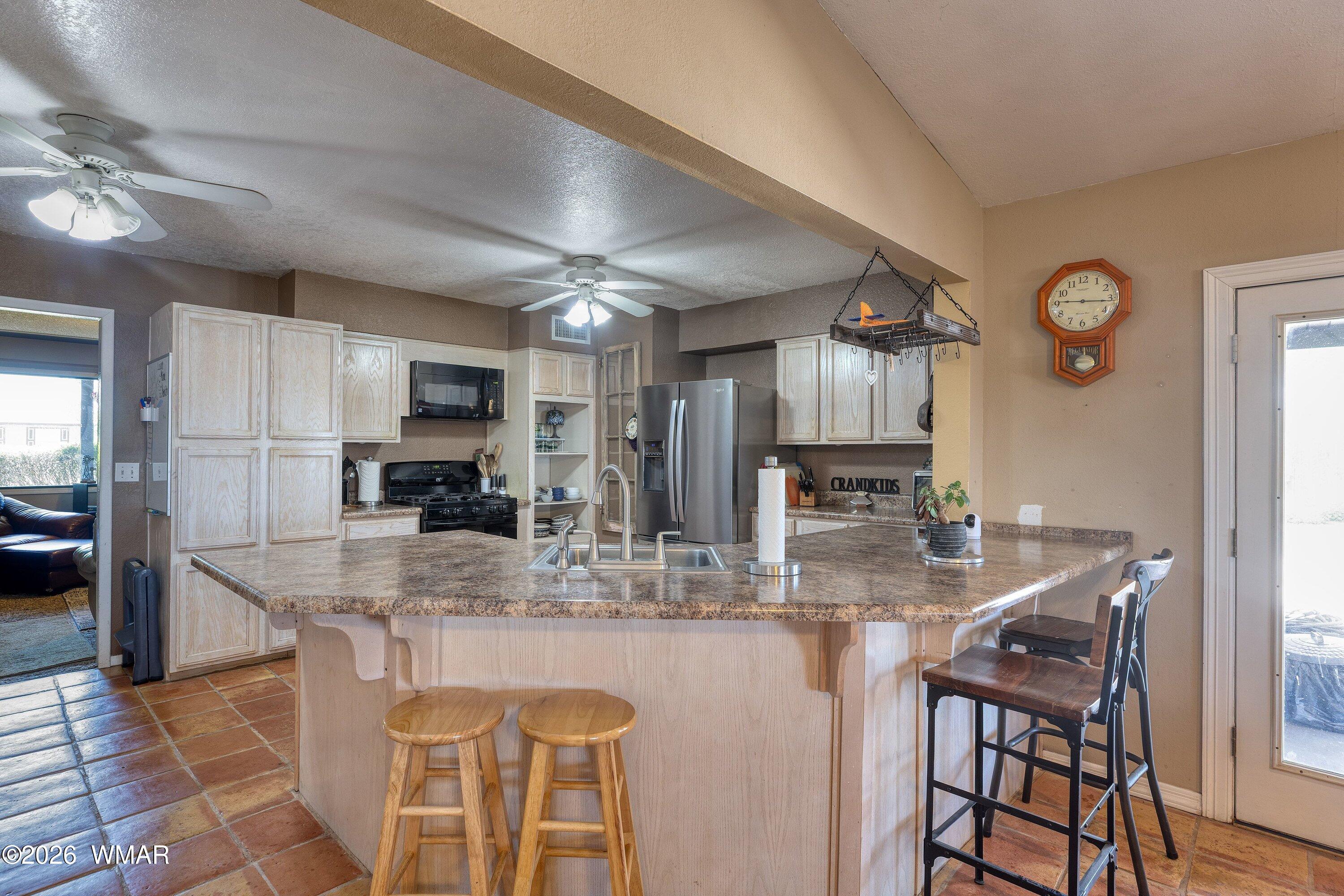1114 Ranch Road Taylor, AZ 85939 - Photo 11 of 32 a kitchen with kitchen island granite countertop a sink and cabinets