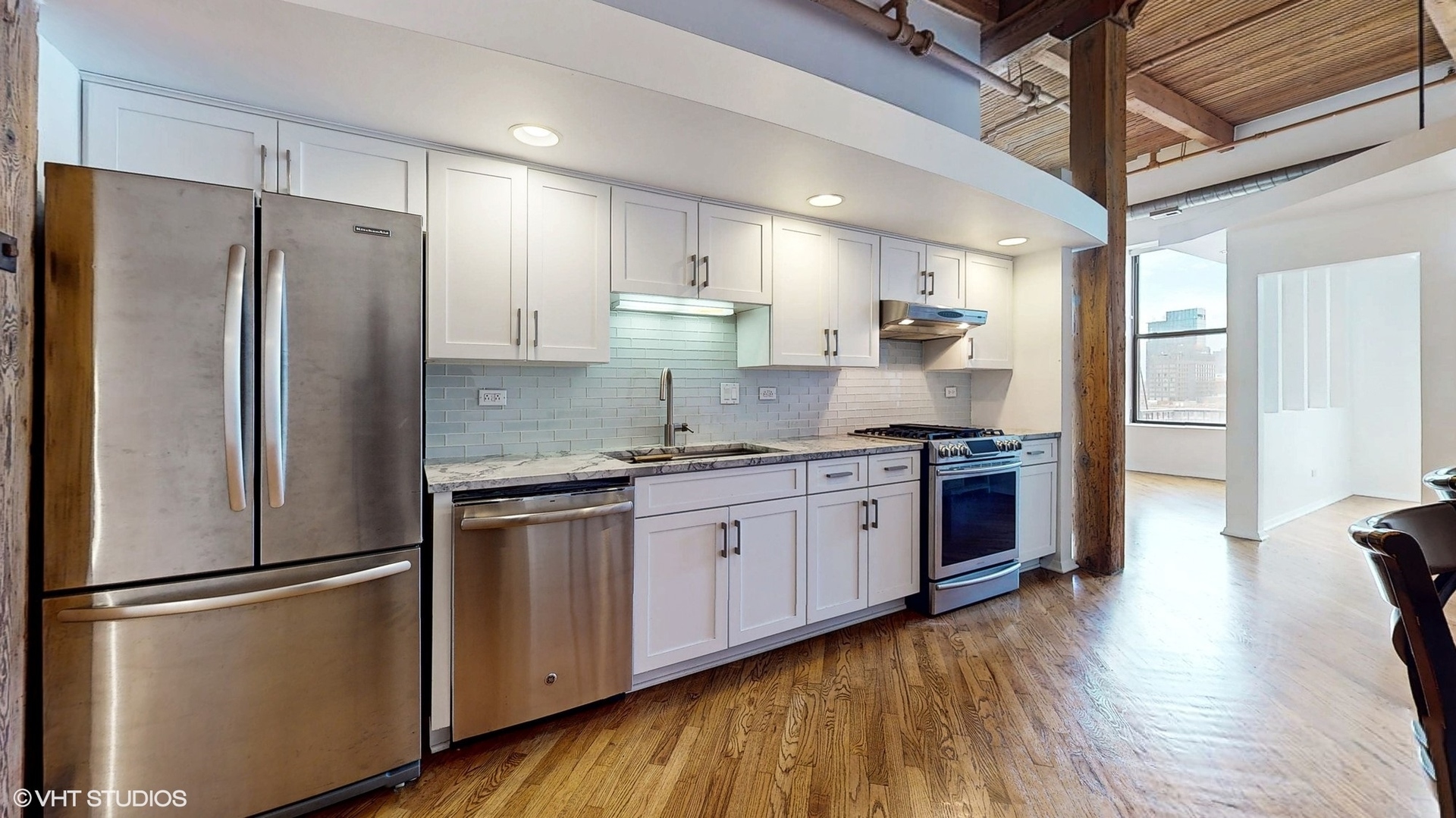 616 West Fulton Street, Unit 609 Chicago, IL 60661 - Photo 6 of 23 a kitchen with stainless steel appliances granite countertop a refrigerator a stove a sink dishwasher and a refrigerator with wooden floor