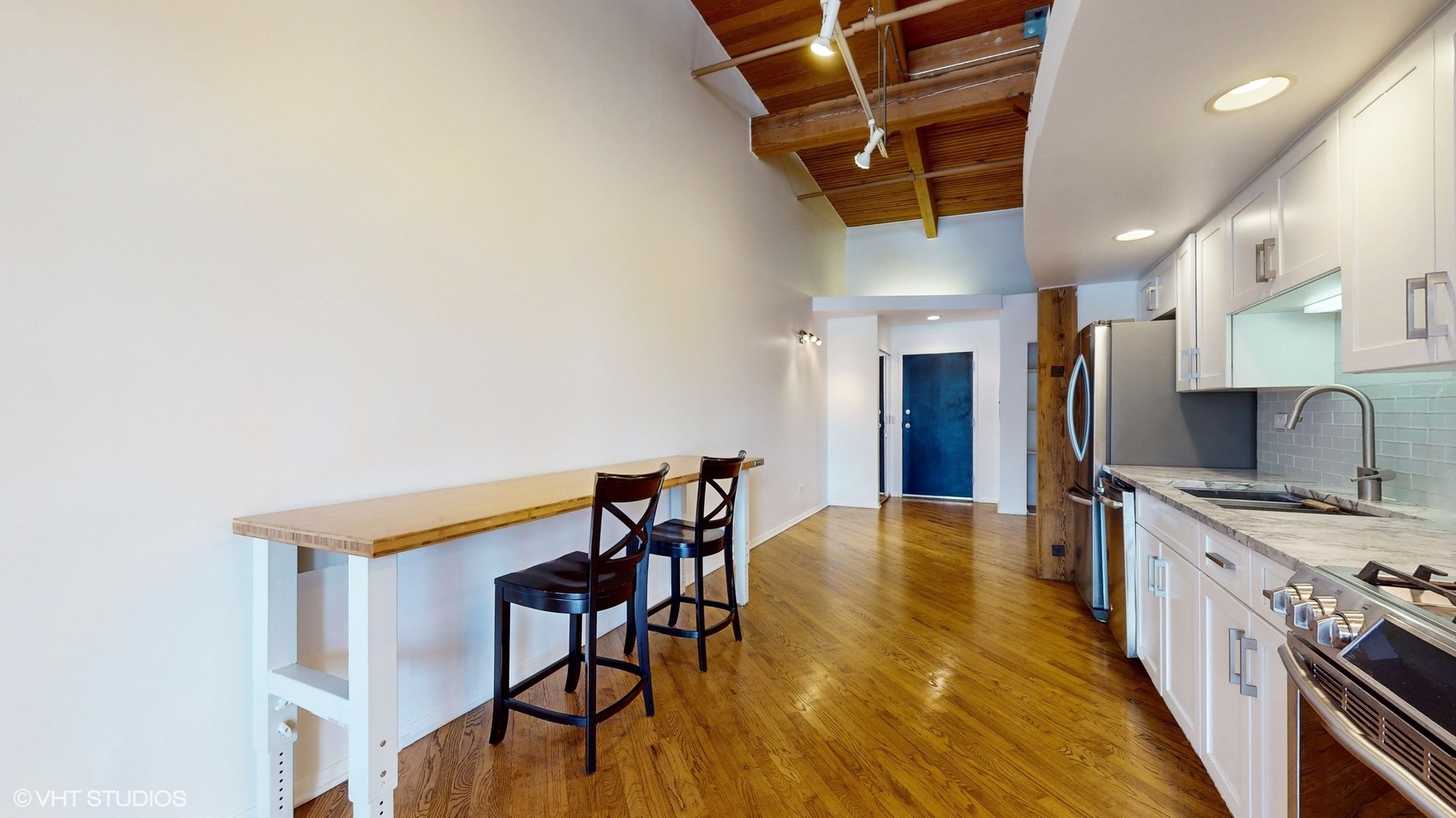 616 West Fulton Street, Unit 609 Chicago, IL 60661 - Photo 7 of 23 a kitchen with stainless steel appliances granite countertop a dining table chairs a refrigerator and cabinets