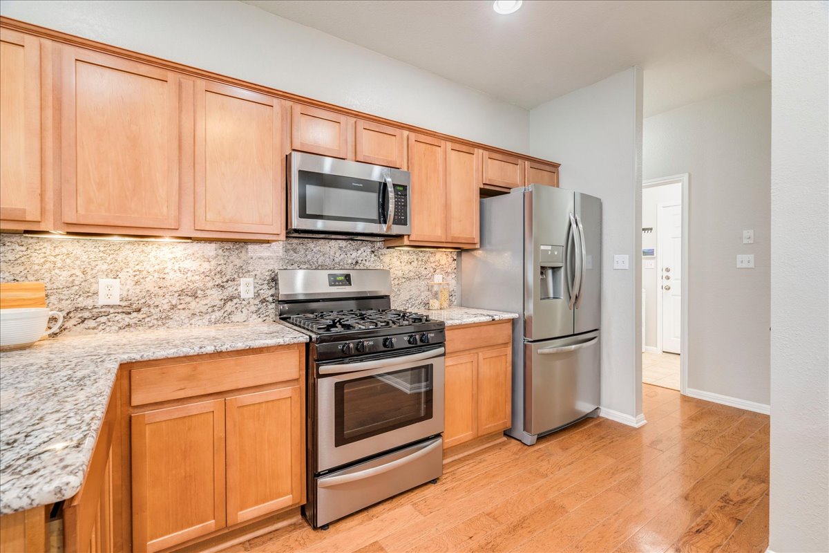 1151 Stone Rim Loop Buda, TX 78610 - Photo 11 of 36 The kitchen features stainless steel appliances granite countertops continued up as backsplash