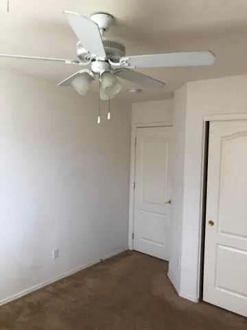 an empty room with a fan and a fan