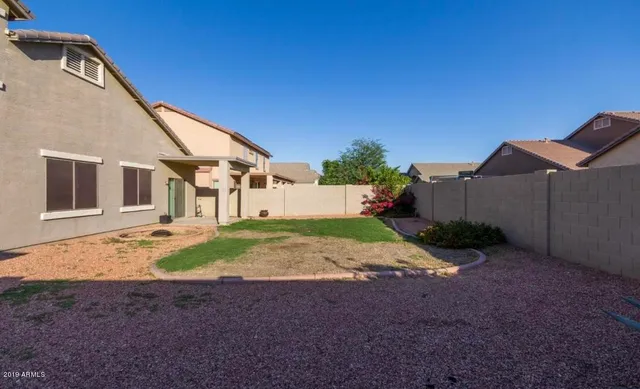 a view of a house with backyard and trees
