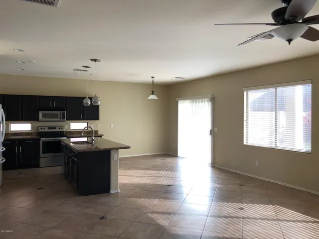 a kitchen with stainless steel appliances kitchen island granite countertop a stove a sink and a refrigerator