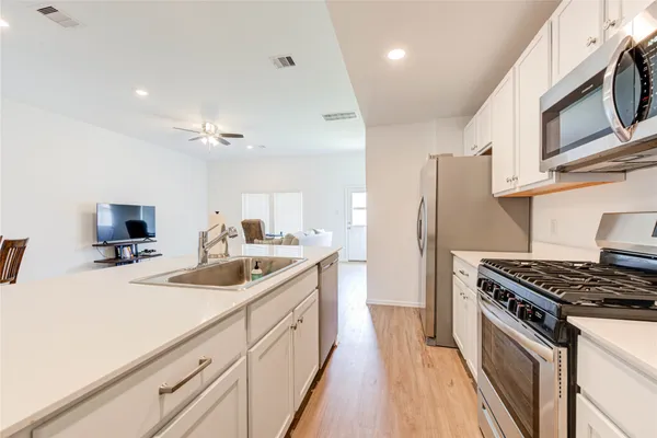 a kitchen with stainless steel appliances granite countertop a sink stove and refrigerator