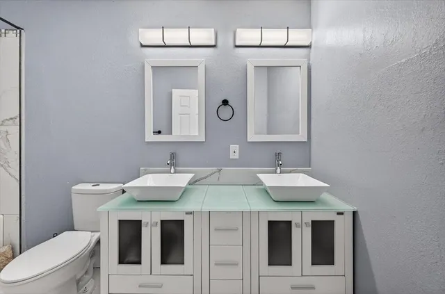 a bathroom with a toilet sink and mirror