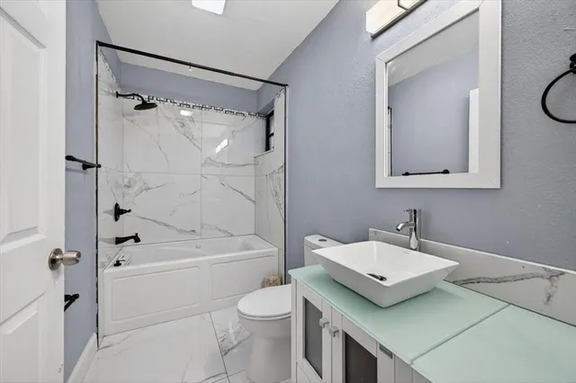 a bathroom with a sink a toilet and a mirror