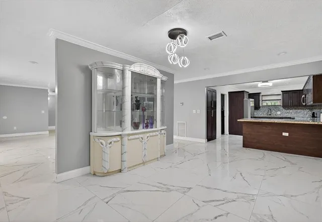 a large white kitchen with kitchen island a sink stainless steel appliances and cabinets