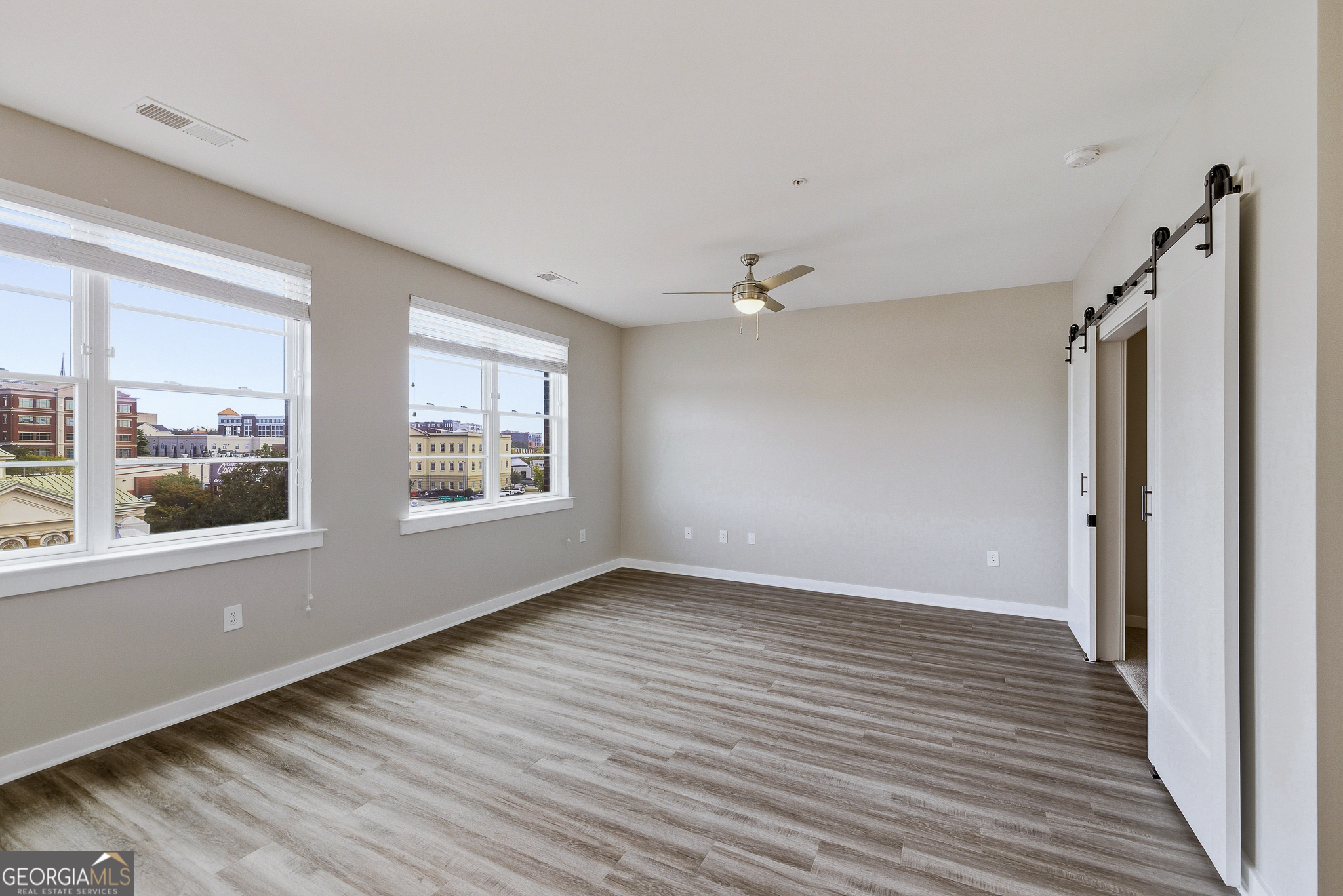 100 Prince Avenue, Unit A303 Athens, GA 30601 - Photo 16 of 27 a view of an empty room with wooden floor and a window