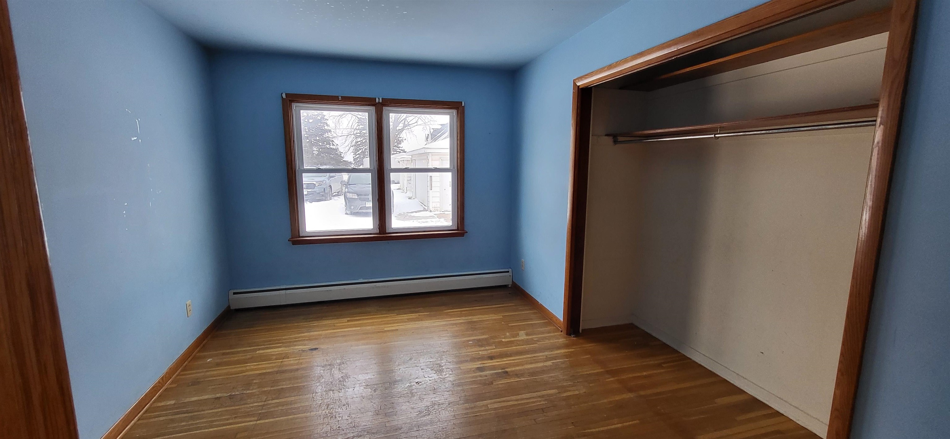 207 East 3rd Street Superior, WI 54880 - Photo 14 of 22 Unfurnished bedroom featuring dark wood-style flooring, baseboard heating, and a closet