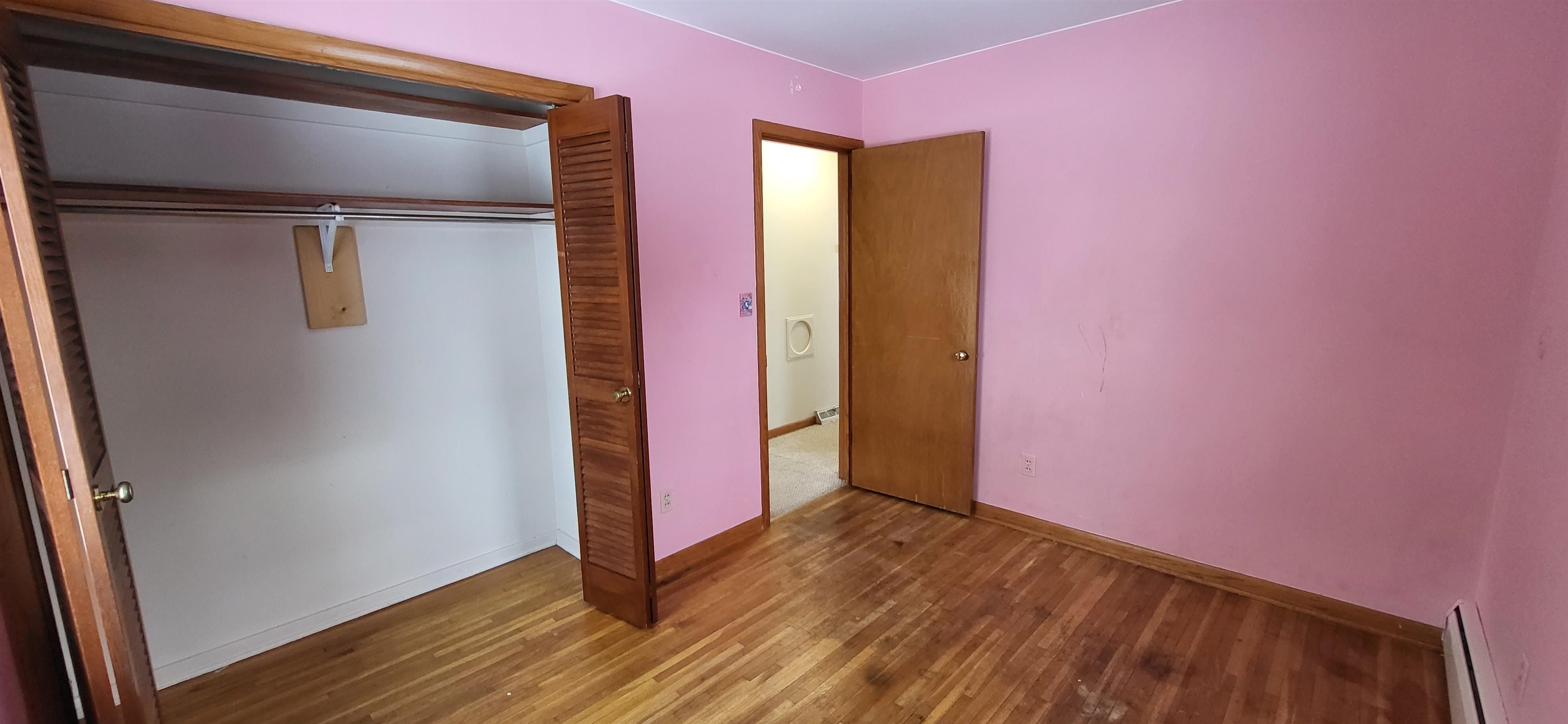 207 East 3rd Street Superior, WI 54880 - Photo 18 of 22 Unfurnished bedroom with wood-type flooring, a closet, and a baseboard radiator