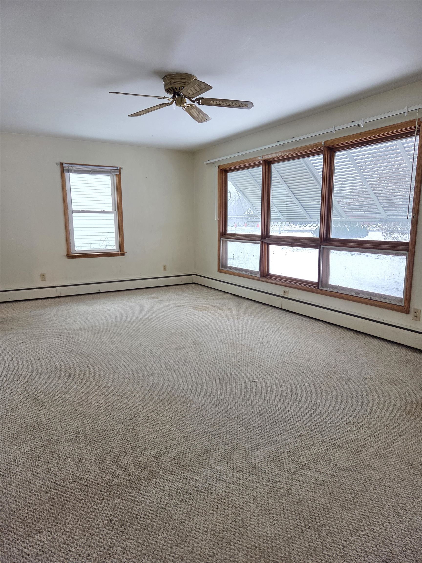 207 East 3rd Street Superior, WI 54880 - Photo 7 of 22 Unfurnished room featuring baseboard heating, light carpet, and ceiling fan