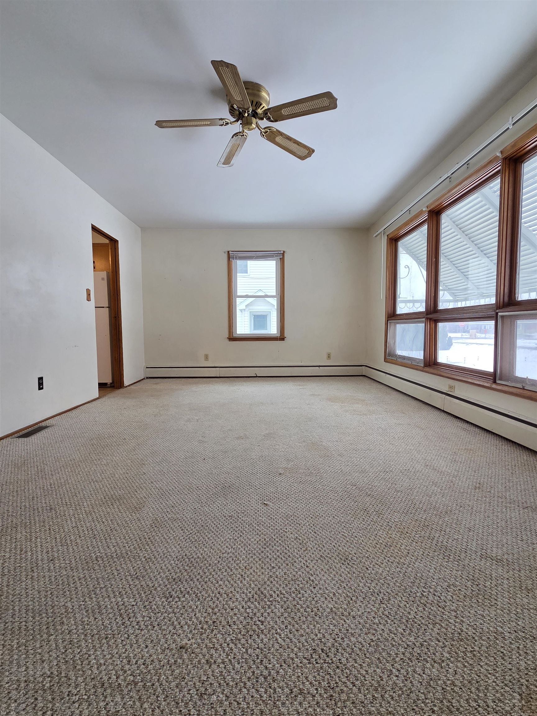 207 East 3rd Street Superior, WI 54880 - Photo 8 of 22 Carpeted empty room featuring ceiling fan and a baseboard radiator