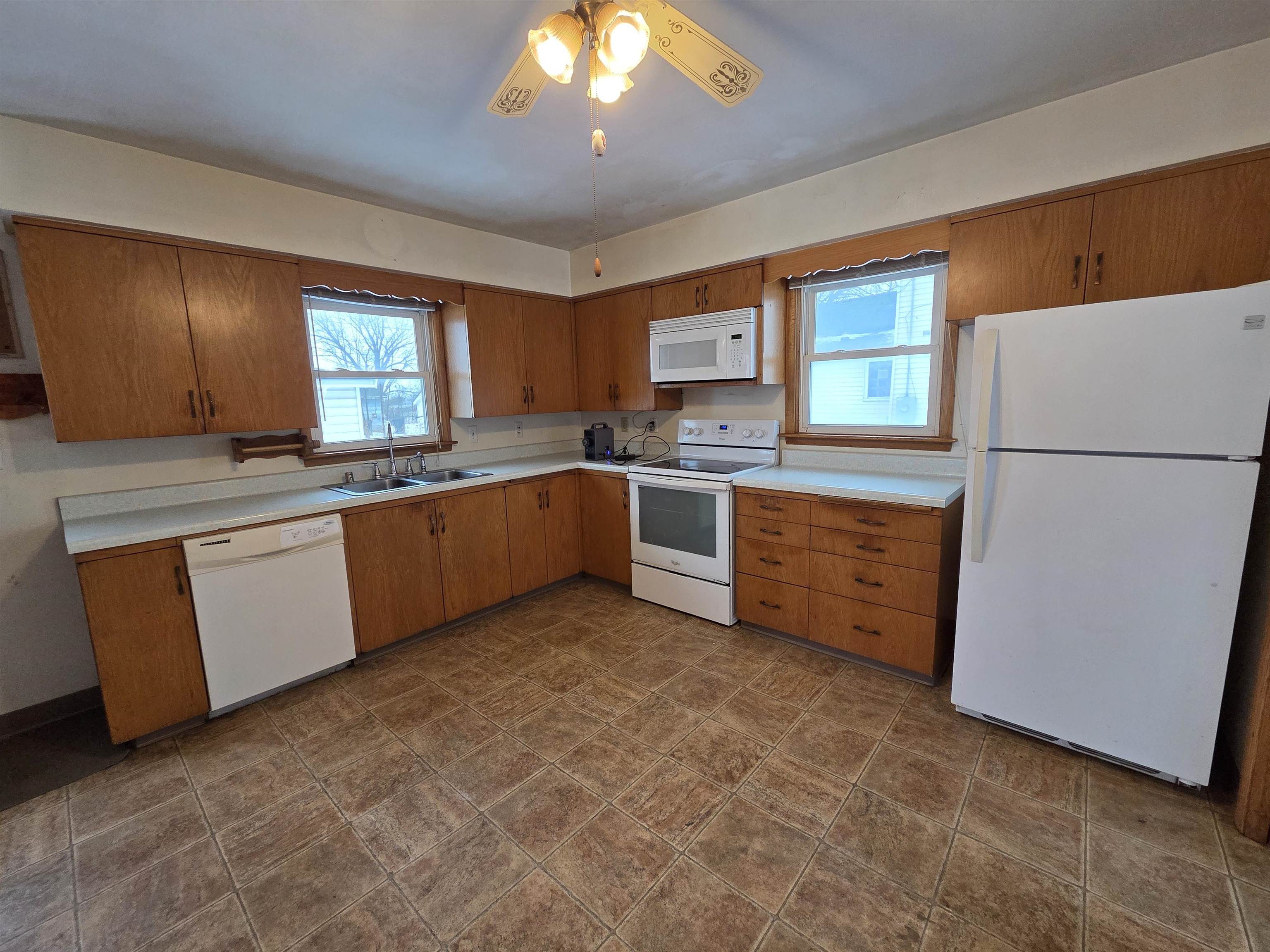 207 East 3rd Street Superior, WI 54880 - Photo 10 of 22 Kitchen with white appliances, brown cabinetry, light countertops, and ceiling fan