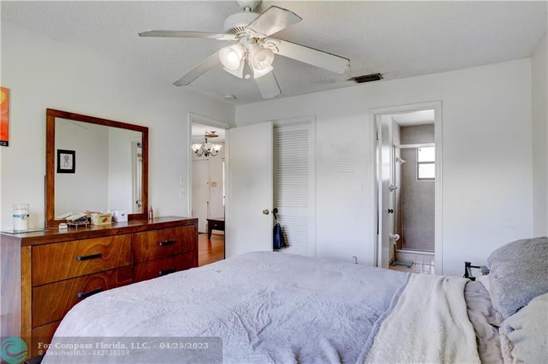 9649 Northwest 4th Street, Unit 5E Coral Springs, FL 33071 - Photo 11 of 30 a bedroom with a bed and a chandelier