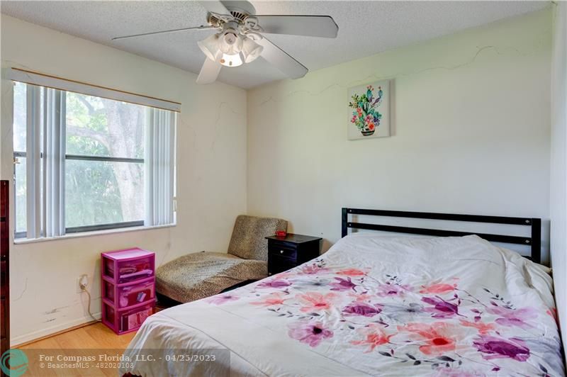 9649 Northwest 4th Street, Unit 5E Coral Springs, FL 33071 - Photo 13 of 30 a bedroom with a bed and a chandelier